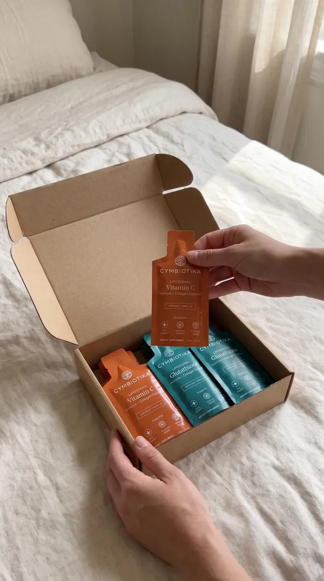 Hands unbox a mailer of Cymbiotika pouches